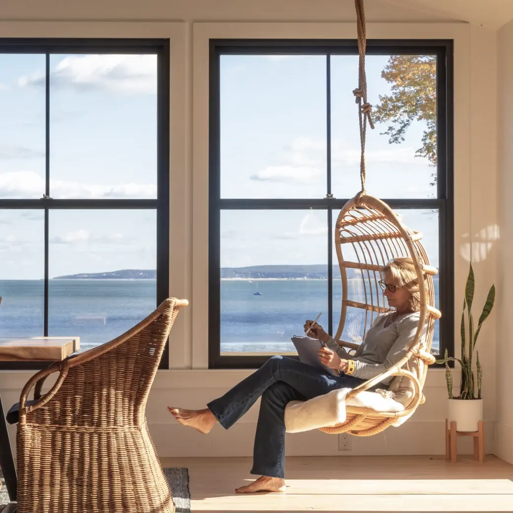 A person in a white outfit on a tennis court, preparing to hit the ball with a racket.