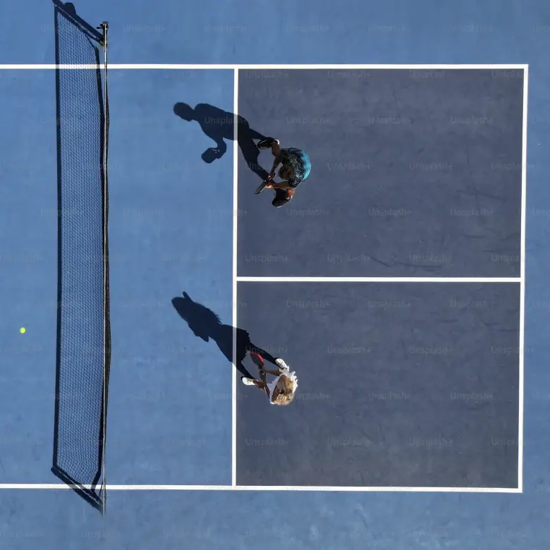 Interior of a grand building with tall arched windows, ornate marble columns, decorative molding, and a large chandelier with round lights hanging from the ceiling.