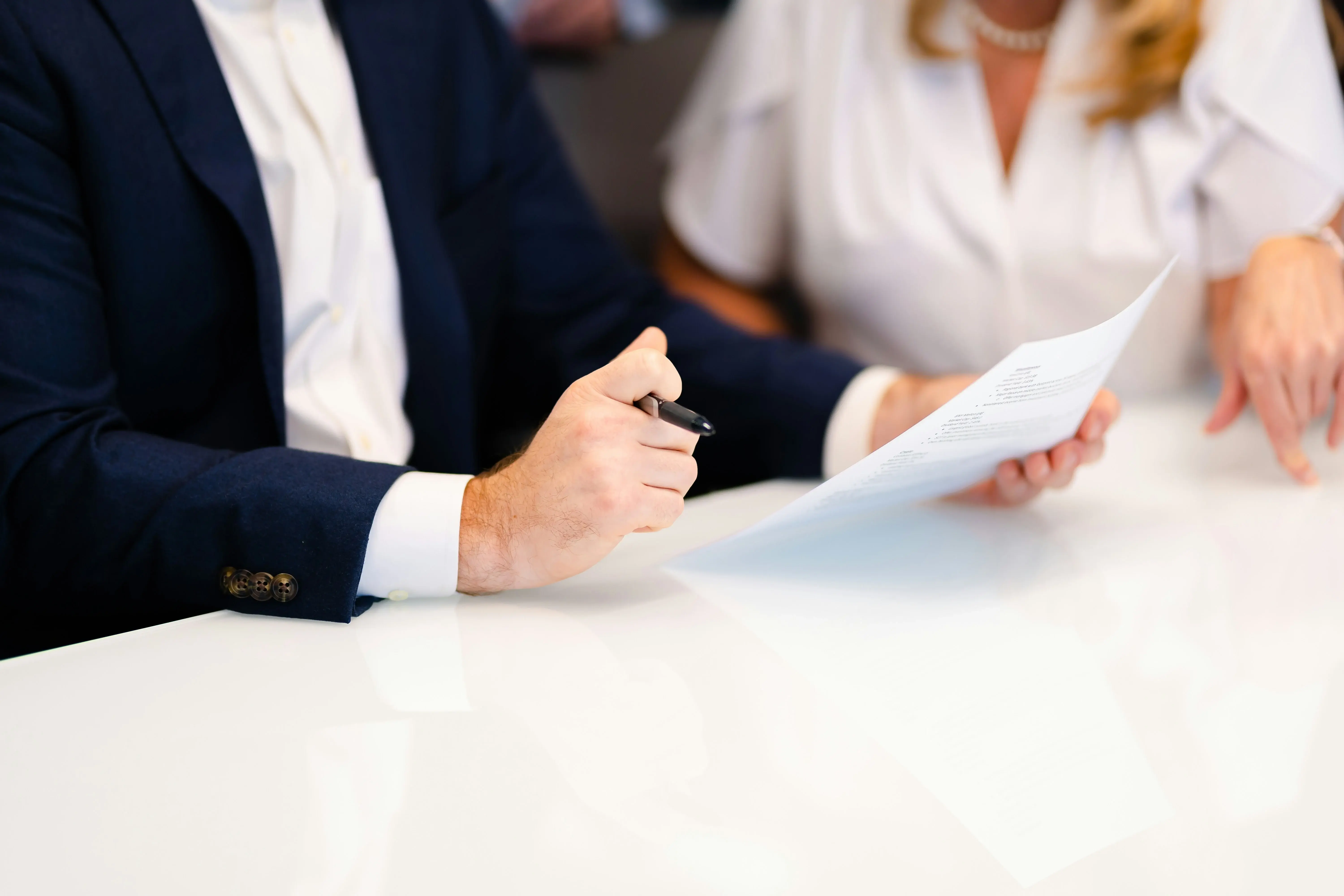 Business professionals reviewing and discussing a document at a meeting table.